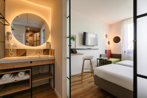 Habitación de hotel con lavabo y espejo en Campanile Krakow South en Cracovia