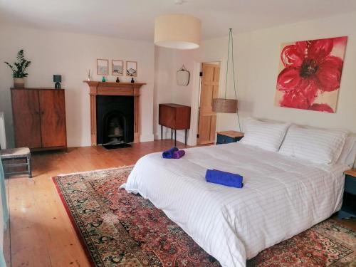 a bedroom with a white bed and a fireplace at Bryn Capel, Gwynfe in Gwynfe