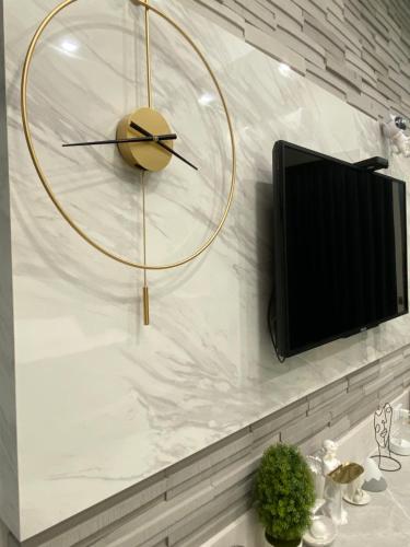 a clock on a wall next to a tv at 漫光時旅民宿-電子入住 in Taitung City