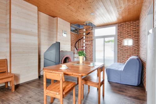 une salle à manger avec une table et une cheminée dans l'établissement Maison pour 7 à 100m de la plage - Jardin, à La Barre-de-Monts