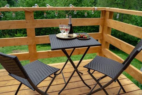 a table with a bottle of wine and two chairs at Chalet Kosorky in Čadca