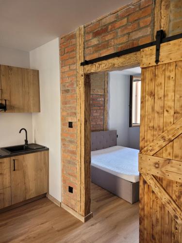 a bedroom with a bed and a brick wall at Apartamenty Majer Łeba Centrum in Łeba