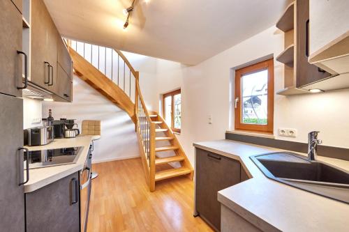 a kitchen with a staircase in the background at Haus Alpklang in Garmisch-Partenkirchen