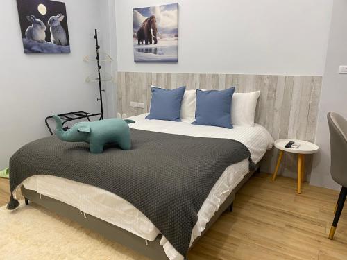 Un dormitorio con una cama con un elefante azul. en 漫光時旅民宿-電子入住, en Taitung