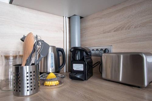 - un comptoir de cuisine avec une tasse d'ustensiles dans l'établissement La Maison de Clara -Etretat Centre - 6 pers, à Étretat