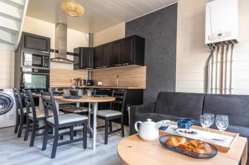 une cuisine et un salon avec un canapé et une table dans l'établissement La Maison de Clara -Etretat Centre - 6 pers, à Étretat