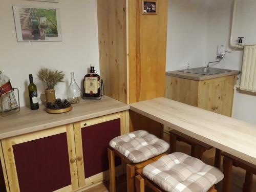 a kitchen with a sink and two bar stools at Chata Bohouš in Petrovice