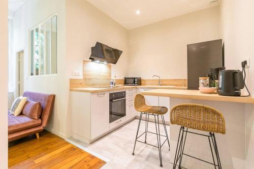 une cuisine avec un comptoir et deux tabourets de bar dans l'établissement Terrasse Saint Michel, à Dijon