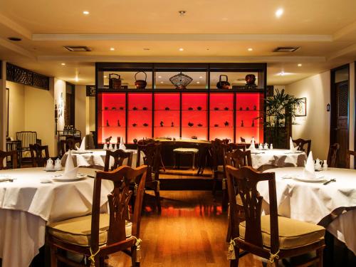 a restaurant with white tables and chairs and red doors at Premier Hotel -Tsubaki- Sapporo in Sapporo