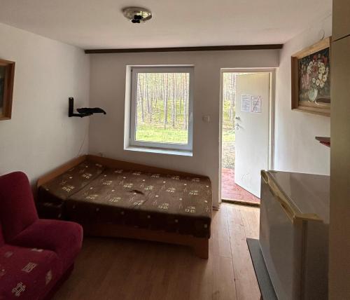 ヘルにあるWydmy Helskieのベッドと窓が備わる小さな客室です。