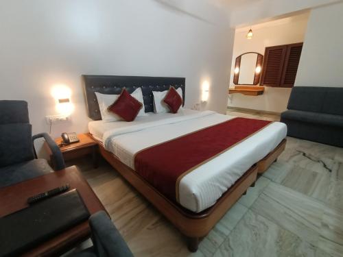 a hotel room with a large bed and a couch at Raja Hotel in Kalyan
