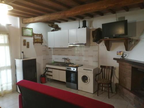 uma cozinha com um fogão e uma máquina de lavar roupa em Casetta in campagna. Bilocale con veranda em Scansano
