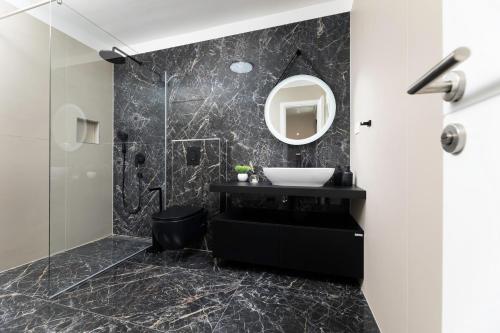 bagno nero con lavandino e specchio di Villa Aria a Klimno