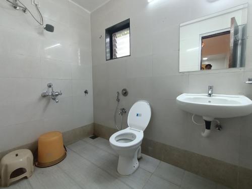 a bathroom with a toilet and a sink at Raja Hotel in Kalyan