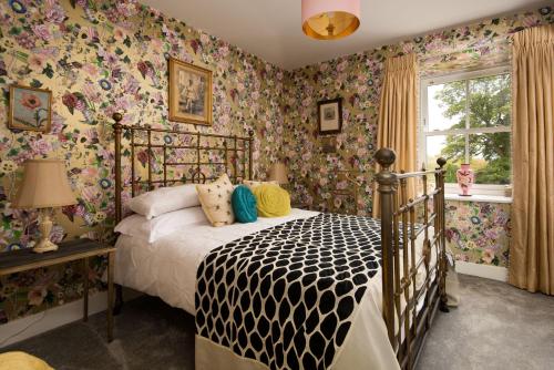 1 dormitorio con 1 cama con papel pintado con motivos florales en Fell End, en Brampton