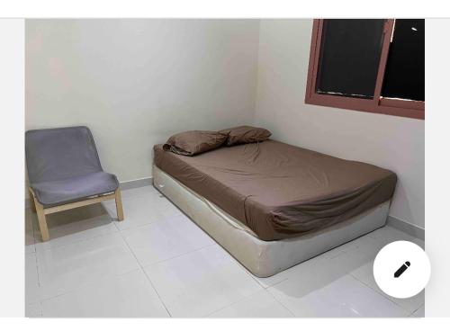 een kleine slaapkamer met een bed en een stoel bij Najm home in Ajman 