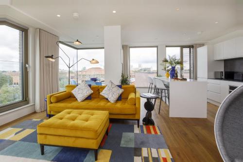 a living room with two yellow couches and a kitchen at Clifford's Skyline in York