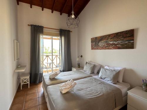 a bedroom with two beds in a room with a window at PATH Latchi amazing beachfront Apartments in Lachi
