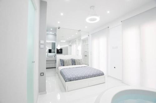 a white bedroom with a bed and a bath tub at Cozy two-bedroom apartment in Athens in Piraeus
