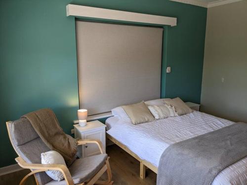 a small bedroom with a bed and a chair at Holli-daze on Coast Moonta Bay in Port Moonta