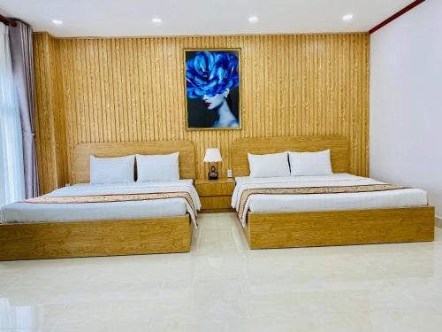 um quarto com duas camas e um quadro na parede em GIANG HÂN HOTEL em Tây Ninh