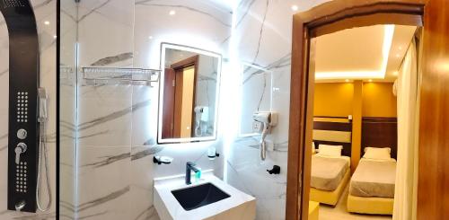 a bathroom with a sink and a shower and a mirror at Petra Town Check-Inn in Wadi Musa