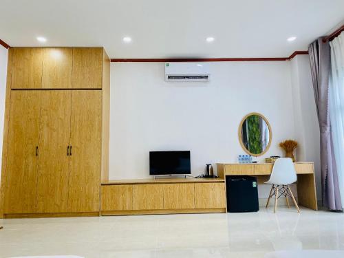 uma sala de estar com uma televisão e uma porta de madeira em GIANG HÂN HOTEL em Tây Ninh