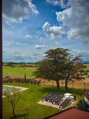 a picnic table and a tree in a field at Casale Solindio in La Pieve