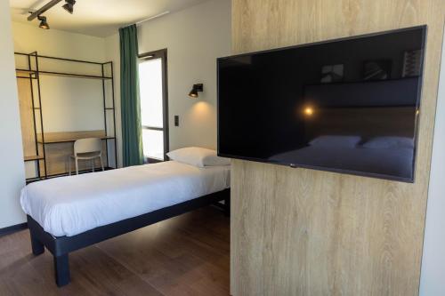 Habitación de hotel con TV de pantalla plana grande. en Ibis Marseille Marignane Technopole en Marignane