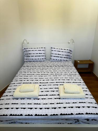 Una cama blanca con dos almohadas. en Spitaki, en Polis Chrysochous