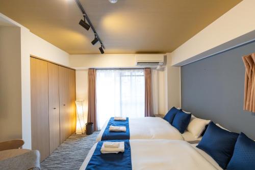 a hotel room with a large bed and a window at F cross EBISU in Osaka