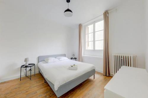 a white bedroom with a bed and a window at Le White Cozy - Lyon - Croix Rousse in Lyon