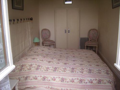 a bedroom with a large bed with two chairs at Chambres d'hôtes & Gîtes du Château de Grand Rullecourt in Grand Rullecourt
