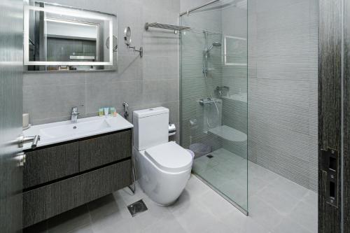 a bathroom with a toilet and a sink and a shower at Modern Studio with Pool & Gym Access in Dubai
