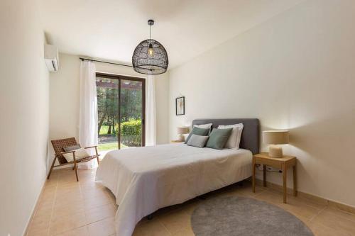 a white bedroom with a bed and a window at Comfort relax w pool near beach in Alvor