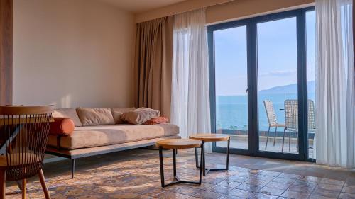 a living room with a couch and a large window at Azar Luxury Suites in Vlorë