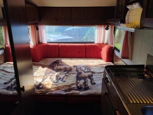 małe łóżko z tyłu samochodu w obiekcie 4 vietīga kempera noma w mieście Grobiņa