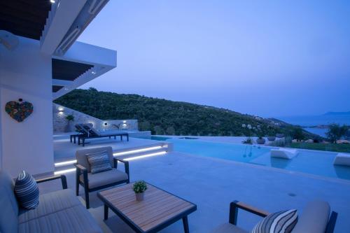 a patio with a table and chairs and a pool at Song of the Sea in Sivota