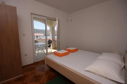 a bedroom with a bed with two orange boxes on it at Apartments and rooms by the sea Pag - 6311 in Pag