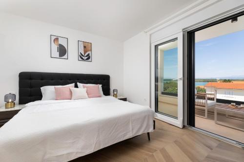 ein Schlafzimmer mit einem großen Bett und einem großen Fenster in der Unterkunft Villa Terra Bianca in Klimno