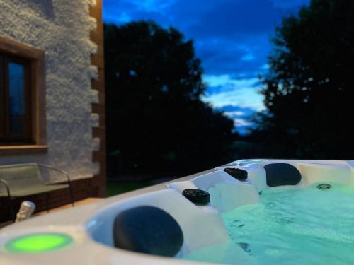 a bath tub filled with water next to a building at Pass the Keys Spectacular 7BR House Hot Tub and Gardens in Gretna in Gretna Green