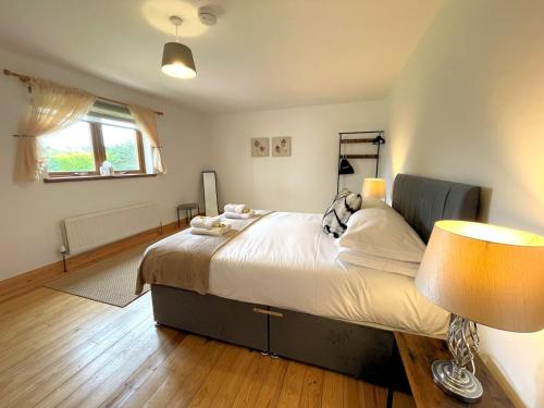 a bedroom with a large bed and a window at Pass the Keys Spectacular 7BR House Hot Tub and Gardens in Gretna in Gretna Green