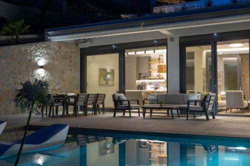 a patio with a table and chairs next to a pool at Song of the Sea in Sivota