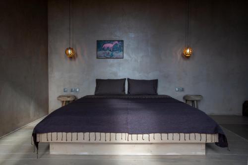 a bedroom with a large bed with a purple blanket at Life Gallery Hotel & Spa in Korçë