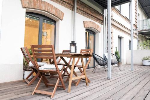 un tavolo e sedie in legno su un patio di Central Park Apartments a Brno