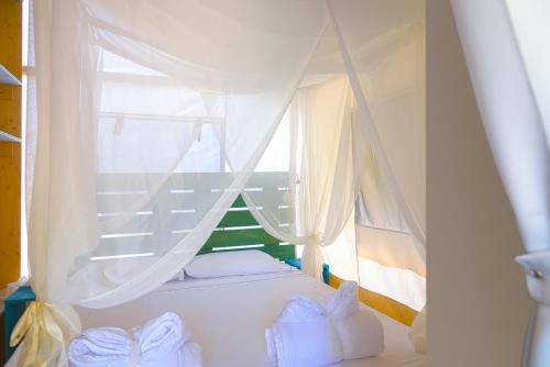 a bedroom with a white bed with a window at Camping Lacona Pineta in Capoliveri