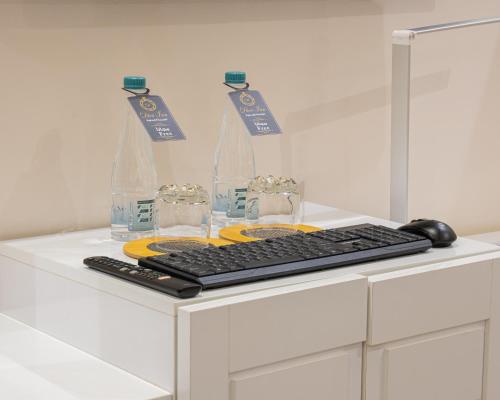 a white desk with a computer keyboard and water bottles at Dior Inn Apartment Hotel in Jeddah