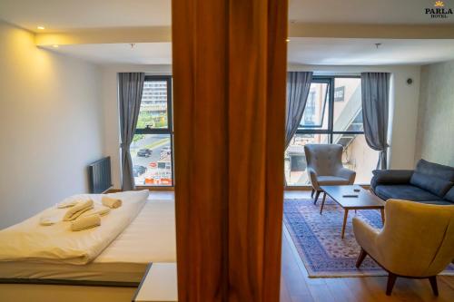 1 dormitorio con 1 cama y sala de estar con ventana en Parla Suite Hotel en Esenyurt