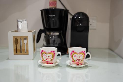two hello kitty coffee cups sitting on a counter at Dior Inn Apartment Hotel in Jeddah