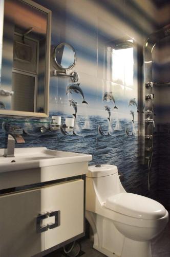 a bathroom with a toilet and a sink with birds on the wall at Royal Retreat ,Kandy in Kandy